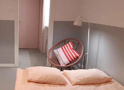 a chair with a pillow sitting next to a bed at Lovely Madly Apartment in Kraków