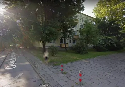 a person walking down a street next to a building at Lovely Madly Apartment in Kraków