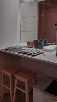 a kitchen with two stools and a counter with dishes at Lovely Madly Apartment in Kraków