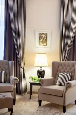 a living room with two chairs and a lamp at Metropolitan Boutique Hotel in Kraków