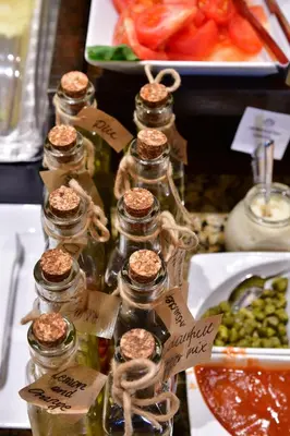 a group of bottles filled with food on a table at Metropolitan Boutique Hotel in Kraków