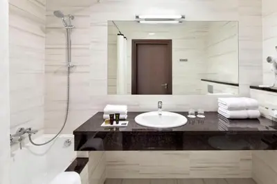 a bathroom with a sink and a shower and a mirror at Metropolitan Boutique Hotel in Kraków