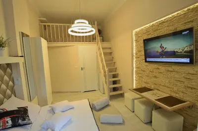 a living room with a tv on a brick wall at Rainbow Apartments 2 in Kraków