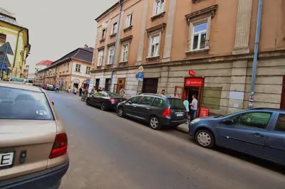 a group of cars parked on the side of a street at Rainbow Apartments 2 in Kraków