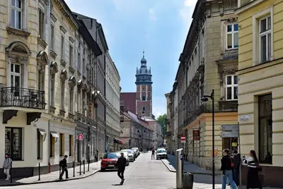 a city street with buildings and people walking down the street at Rainbow Apartments 2 in Kraków
