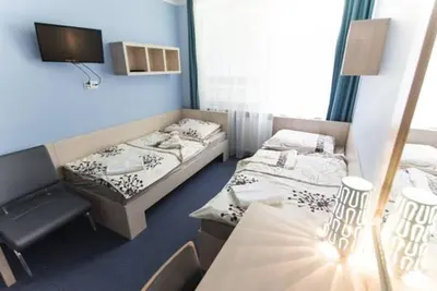 a room with two beds and a table in it at Strumyk in Kraków