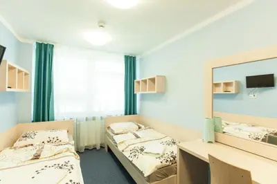 a hotel room with two beds and a chair at Strumyk in Kraków