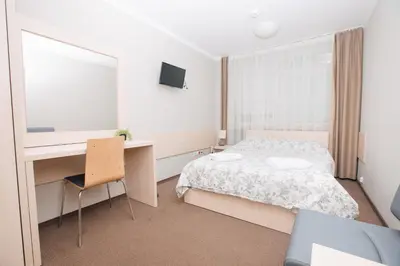 a bedroom with a bed and a desk and a computer at Strumyk in Kraków