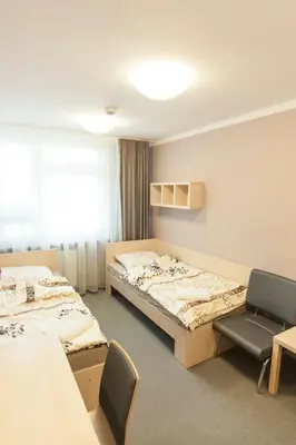 a hospital room with two beds and a tv at Strumyk in Kraków