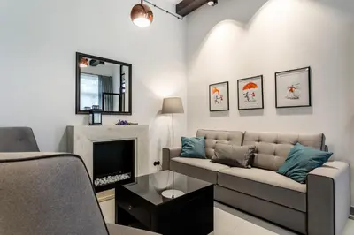 a living room with a couch and a fireplace at 3D WYGODA Apartamenty in Kraków