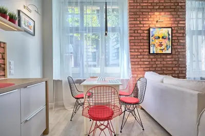 a kitchen with a table and chairs and a brick wall at 3D WYGODA Apartamenty in Kraków