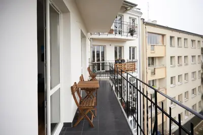 a balcony with two chairs and a table on it at 3D WYGODA Apartamenty in Kraków