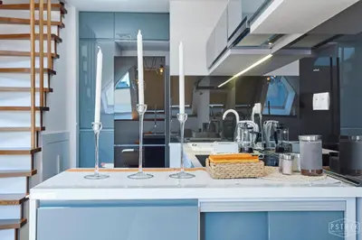 a kitchen with blue cabinets and a counter top at 3D WYGODA Apartamenty in Kraków