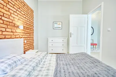 a bedroom with a bed and a brick wall at 3D WYGODA Apartamenty in Kraków