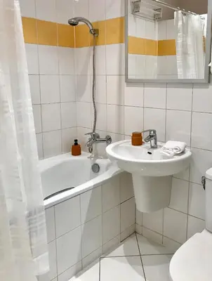 a bathroom with a sink and a tub and a toilet at Tresor Barska Apartments 2.0 in Kraków