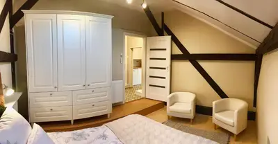 a bedroom with white furniture and a attic at Tresor Barska Apartments 2.0 in Kraków
