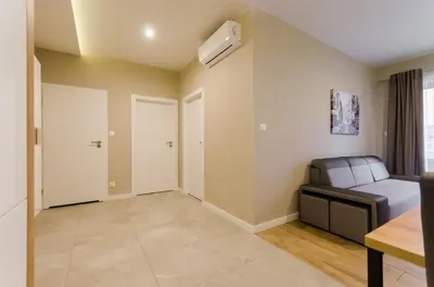 a living room with a couch and a fan at Krakowiak Apartments in Kraków