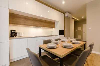 a dining room with a wooden table and chairs at Krakowiak Apartments in Kraków