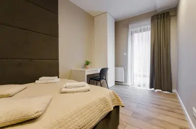 a bedroom with two beds and a desk and a window at Krakowiak Apartments in Kraków