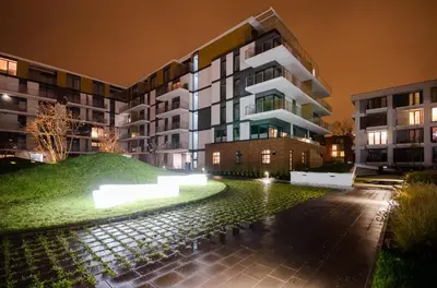 an apartment building at night with a pond in front at Krakowiak Apartments in Kraków