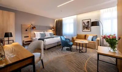 a hotel room with a bed and a couch at Hotel M29 in Kraków