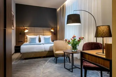 a hotel room with a bed and a table and chairs at Hotel M29 in Kraków