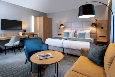 a hotel room with a bed and a couch at Hotel M29 in Kraków