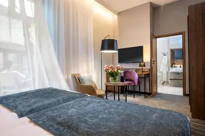 a hotel room with a bed and a desk at Hotel M29 in Kraków