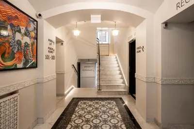 a hallway with stairs and a painting on the wall at Hotel M29 in Kraków