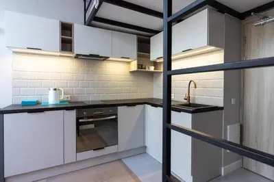 a kitchen with white cabinets and a sink at Apartment NEARTO Old Town Miodowa Parking in Kraków