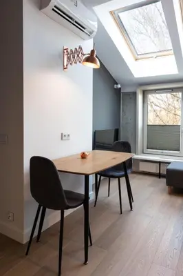 a dining room with a table and chairs and a skylight at Apartment NEARTO Old Town Miodowa Parking in Kraków