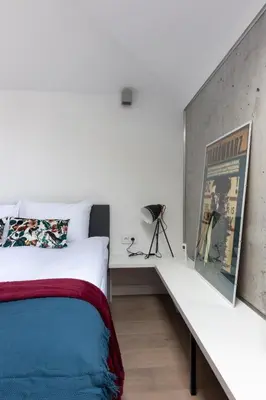 a bedroom with a white bed and a white bench at Apartment NEARTO Old Town Miodowa Parking in Kraków