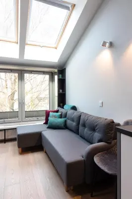 a living room with a couch and two windows at Apartment NEARTO Old Town Miodowa Parking in Kraków