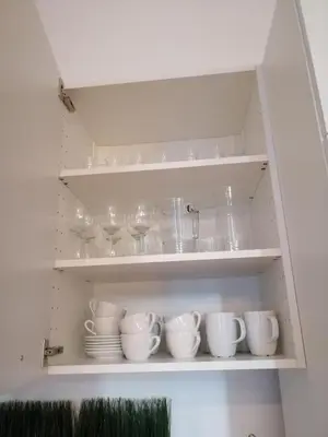 a cupboard with dishes and wine glasses on it at Apartament Galicja in Chrzanów