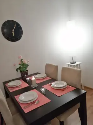 a dining room table with a clock on the wall at Apartament Galicja in Chrzanów
