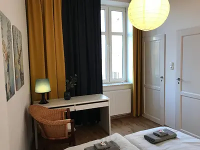 a bedroom with a bed and a desk and a window at Apartament Galicja in Chrzanów