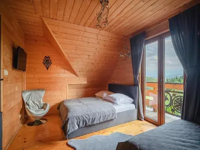 a bedroom with two beds in a wooden cabin at Villa in Nowy Targ with Mountain Views & Pool in Nowy Targ