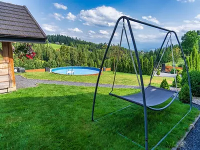 a swing in a yard next to a pool at Villa in Nowy Targ with Mountain Views & Pool in Nowy Targ