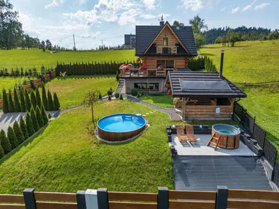 a log home with a large yard with a pool at Villa in Nowy Targ with Mountain Views & Pool in Nowy Targ