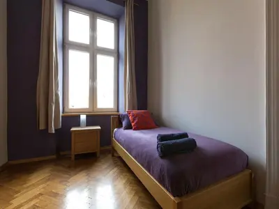 a small bedroom with a bed with a window at Apartment in Krakow near Main Square in Kraków