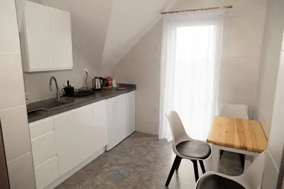 a kitchen with white cabinets and a table and a window at Zajazd u ELiZY in Czajowice