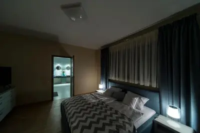a bedroom with a bed with two lamps and a mirror at Natura Villa Spa in Węgrzce