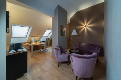 a living room with purple chairs and a desk with a computer at Natura Villa Spa in Węgrzce
