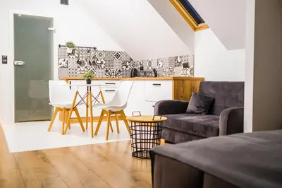 a living room with a couch and a kitchen at Nad Gościńcem in Słopnice