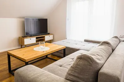 a living room with a couch and a kitchen at Nad Gościńcem in Słopnice
