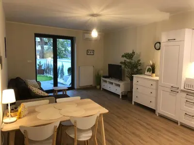 a kitchen and living room with a table and a couch at Wislane Tarasy 2.0 by Atrium Apartments in Kraków