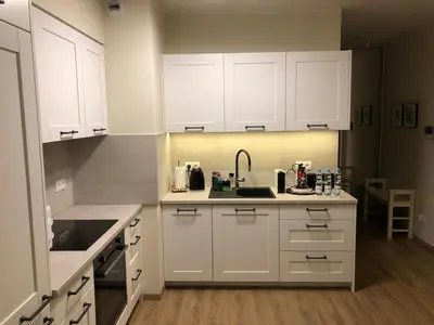 a kitchen with white cabinets and a sink at Wislane Tarasy 2.0 by Atrium Apartments in Kraków