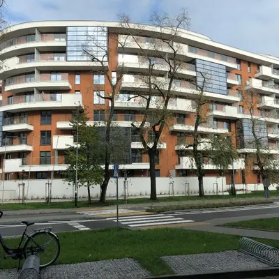 a bike parked in front of a large building at Wislane Tarasy 2.0 by Atrium Apartments in Kraków