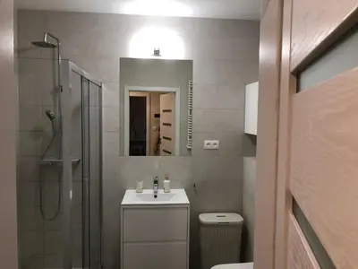 a bathroom with a shower and a sink and a mirror at Wislane Tarasy 2.0 by Atrium Apartments in Kraków