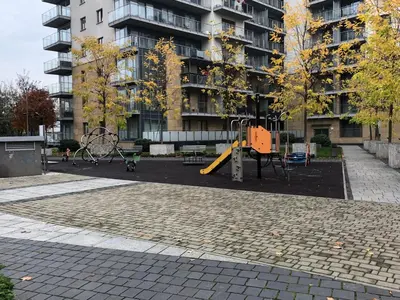 a playground in front of a tall building at Wislane Tarasy 2.0 by Atrium Apartments in Kraków